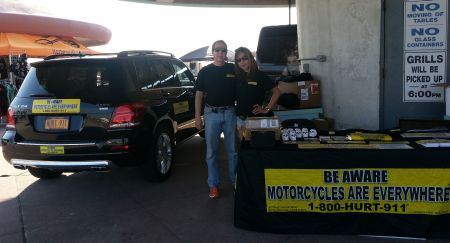 Phil Franckel and his wife Erlyne at Dee Snider's motorcycle event in front of the 1-800-HURT-911 motorcycle lawyers booth