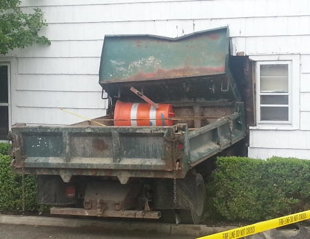 dump truck crashed into the side of a building causing substantial damage