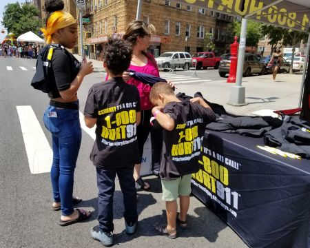 accident attorney Rob Plevy giving out free T-shirts to children at Bronx street fair