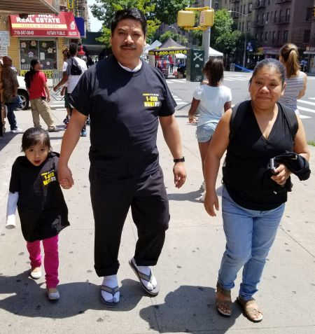 father and daughter wearing 1-800-HURT-911 T-shirts at Bronx street fair