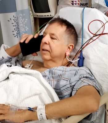 personal injury lawyer and Founding Partner in a hospital recovery room after surgery, speaking with a client who called on the phone 