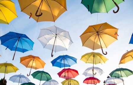 colorful umbrellas in the sky signifying umbrella insurance over underlying insurance